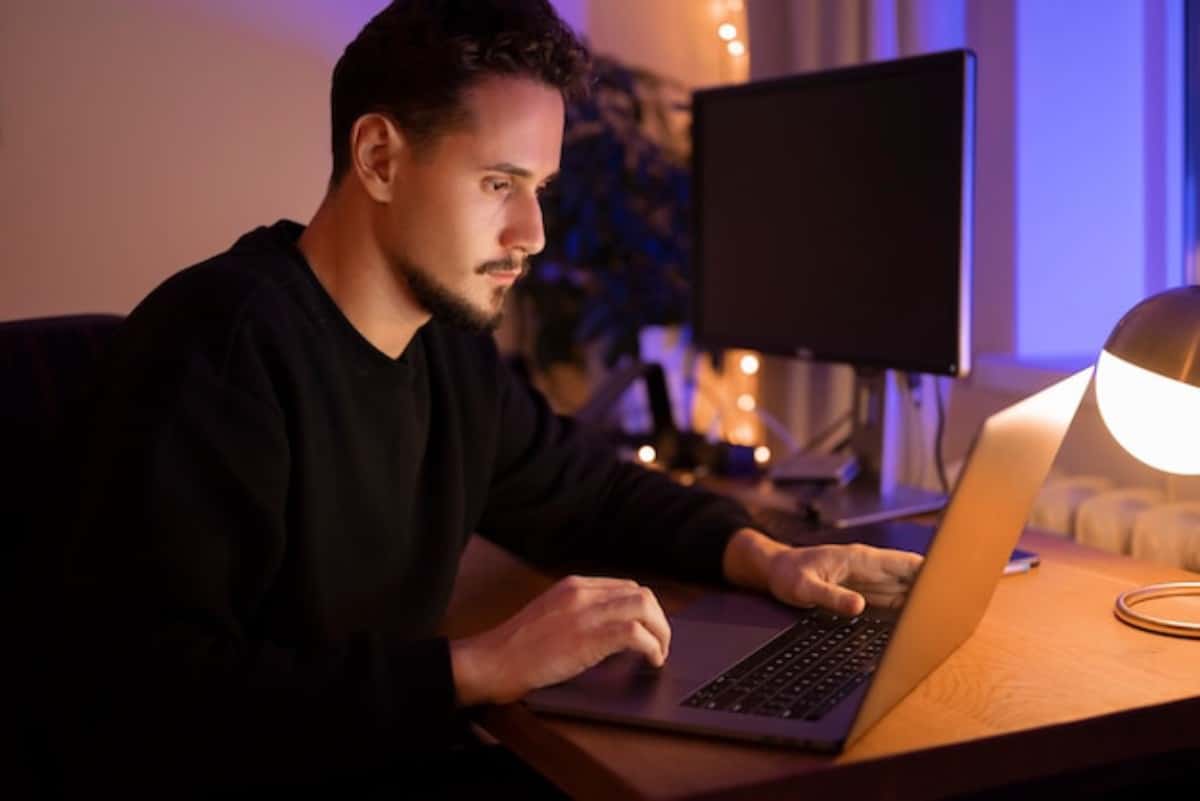 Un homme est sur son ordinateur, entrain de défInir sa stratégie de backlinks pour son site internet grâce à l'IA.